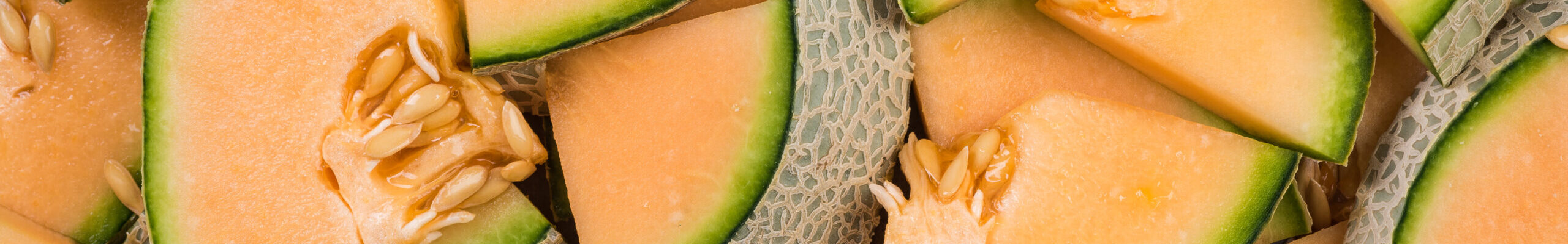 Cantaloupe melon slices, full frame food background.
